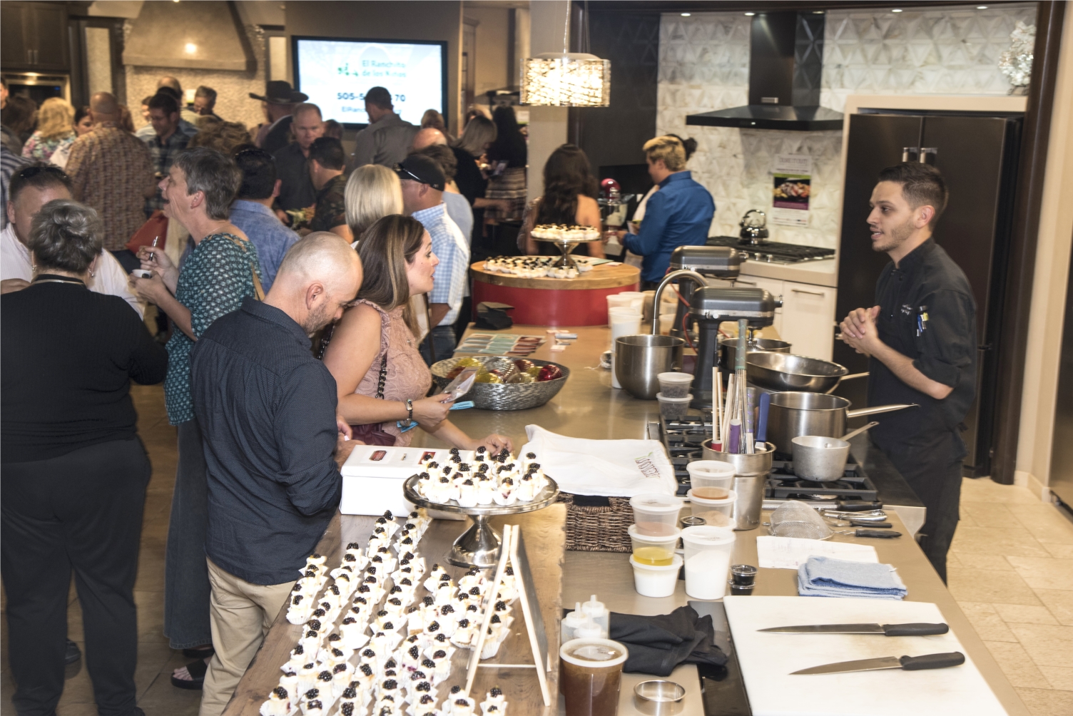 Guest enjoy sampling food at Builders Source Appliance Gallery during the chef based cooking competition "DUKE IT OUT" to raise money for El Ranchito de los Ninos. 