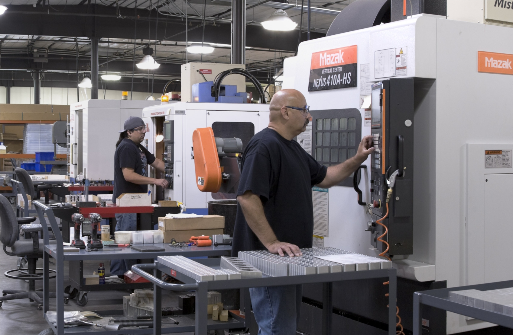 L-R Scott Sanderville (7 yrs) and Ed Varoz (16 yrs) operate CNC machines at Lectrosonics.