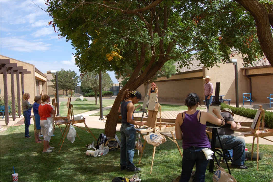 Painting students enjoy a lesson outdoors on a beautiful day.