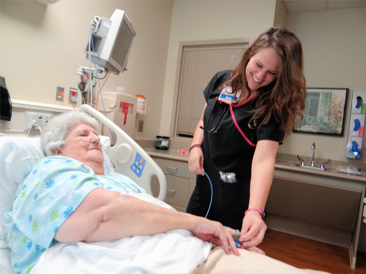 Mary Ellen Kiker, a registered nurse on the cardiac progressive care unit (CPCU) at Tanner Medical Center/Carrollton, checks in on patient Sandra Weathers of Ranburne, Ala.