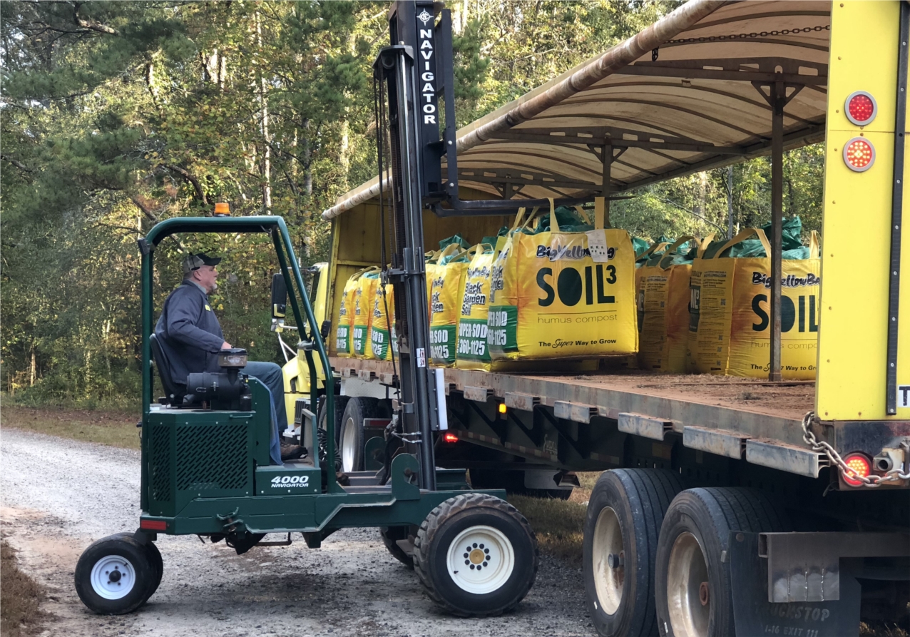 Delivery drivers have embraced recent technology changes to ensure your sod or Soil3 compost arrives on time. Here the driver unloads a cubic yard BigYellowBag full of Soil3.