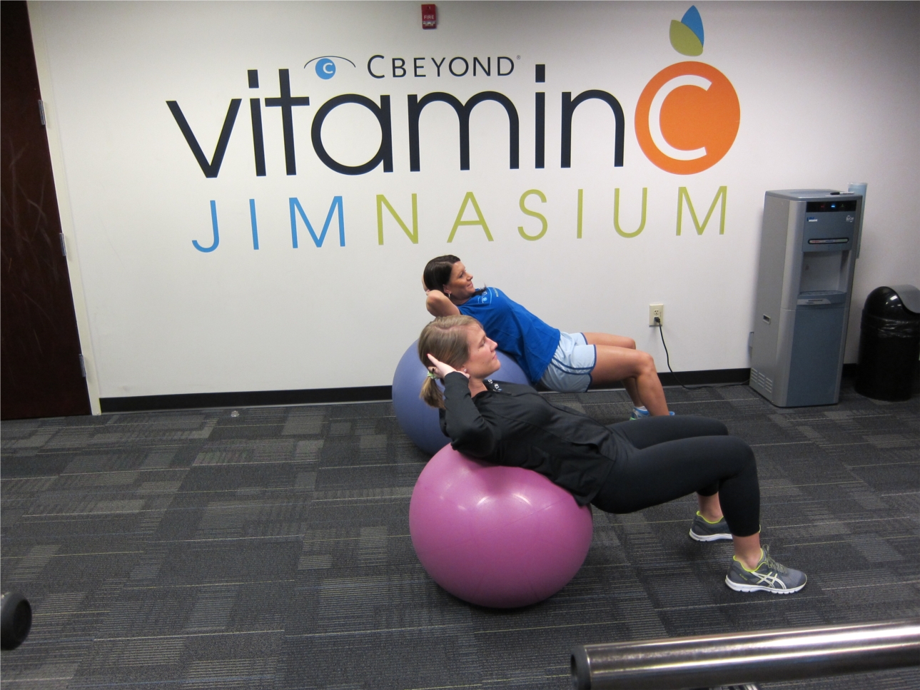 Cbeyond employees Kelly Coffed and Katie Tucker workout in Cbeyond's Jimnasium (named after Cbeyond's Founder, Chairman, President and Chief Executive Officer) 