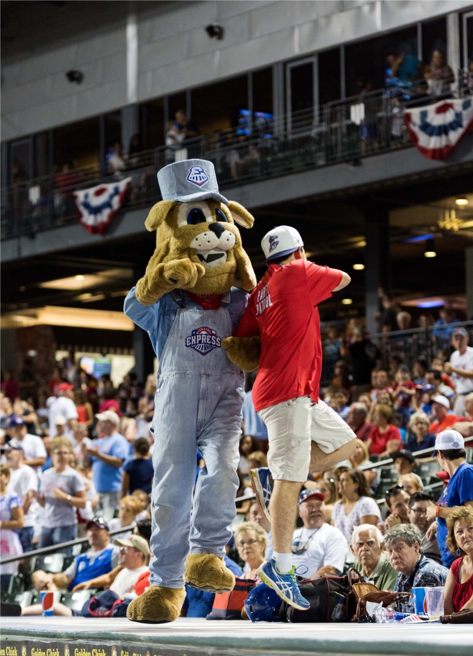 Spike the Round Rock Express mascot and staff dancing on the dugout at a game.  Courtesy Grease Man Photography