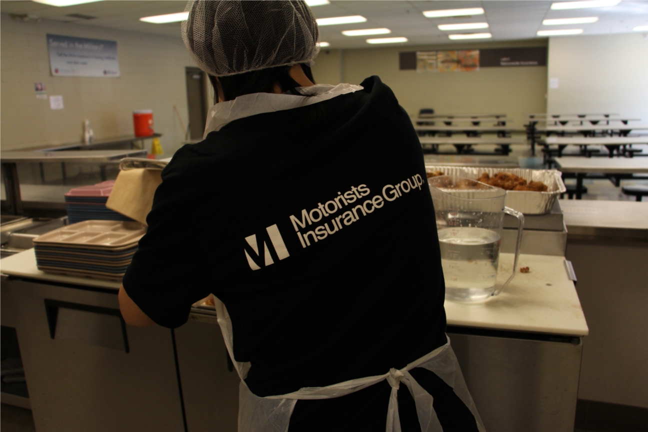 A volunteer from Motorists Insurance Group helps cook lunch at the Faith Mission. 