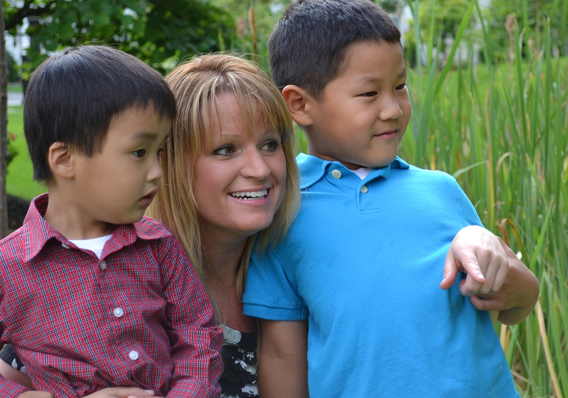 An Astellas employee with her children watching dragonflies in a local marsh area.