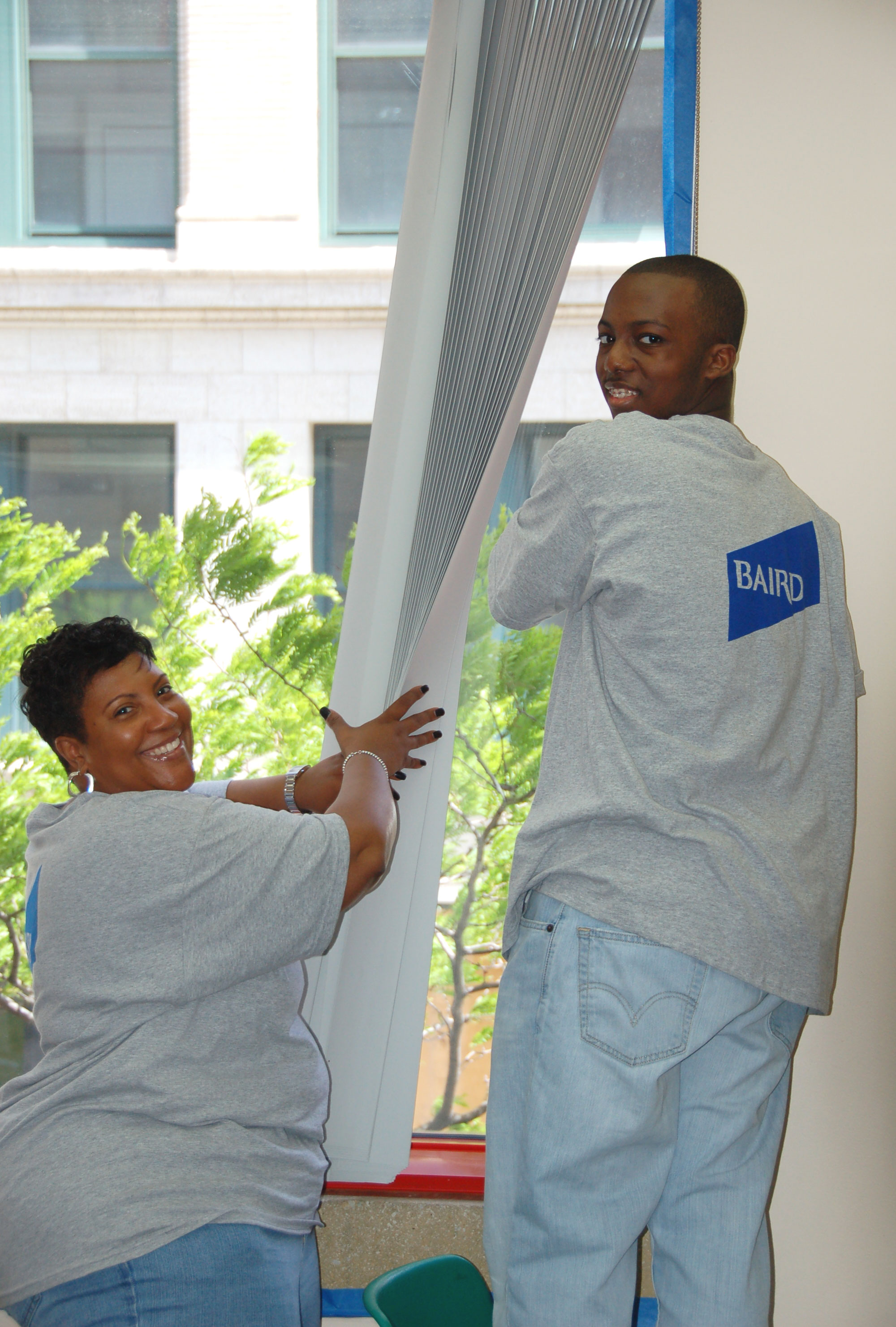 Tonya Joyner, Chicago Investment Banking, and her son Devin Joyner prep the Metro Achievement Center for painting. 