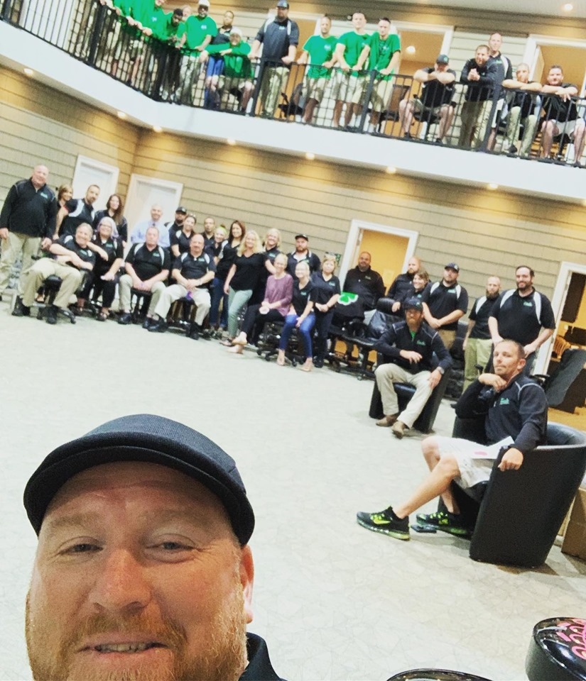 Walter "Reds" Ferris and the Ferris team at one of their monthly team meetings. The team meets each month in their new atrium-style office addition to their showroom, designed specifically to facilitate group discussion for all members of the company.