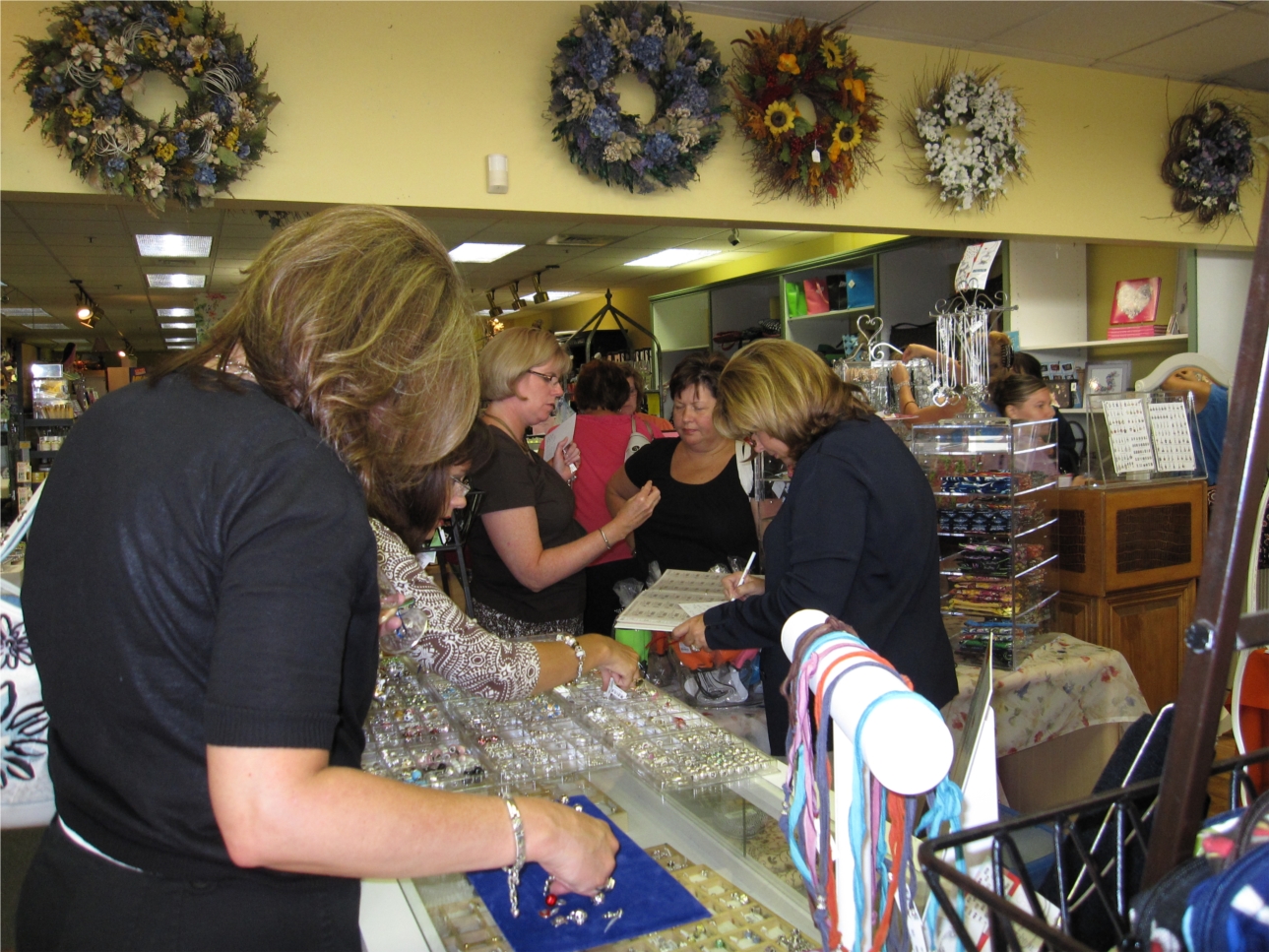 Customers at Heart And Home look over the selection of charms at a "Charms and Chardonnay" party.