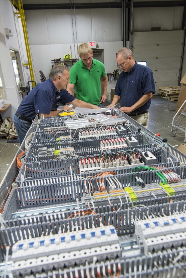 Interstates Panel Shop employees discussing design drawings for one of the many panels they build every year. The panel shop recently built their 3000th panel.