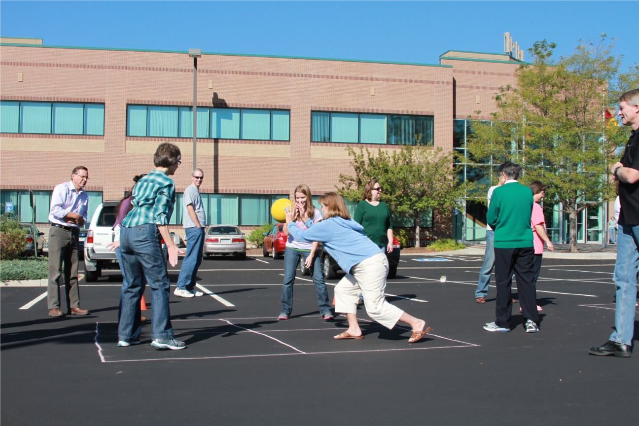 Staff playing four-square game in the parking lot on National Recess Day.
