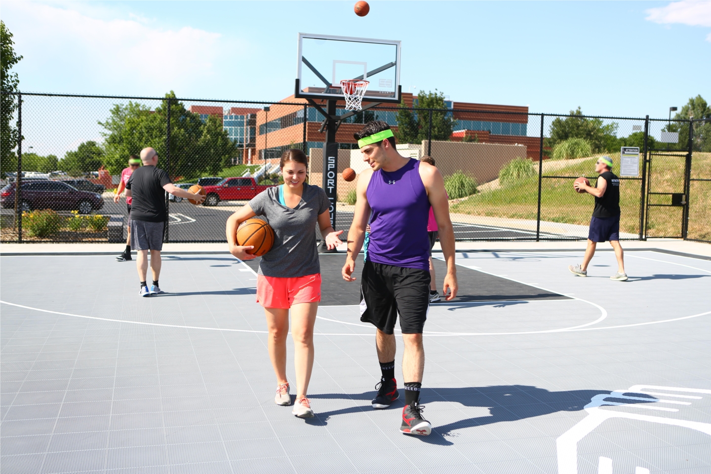 Employees enjoying a game of basketball in the sun. 
