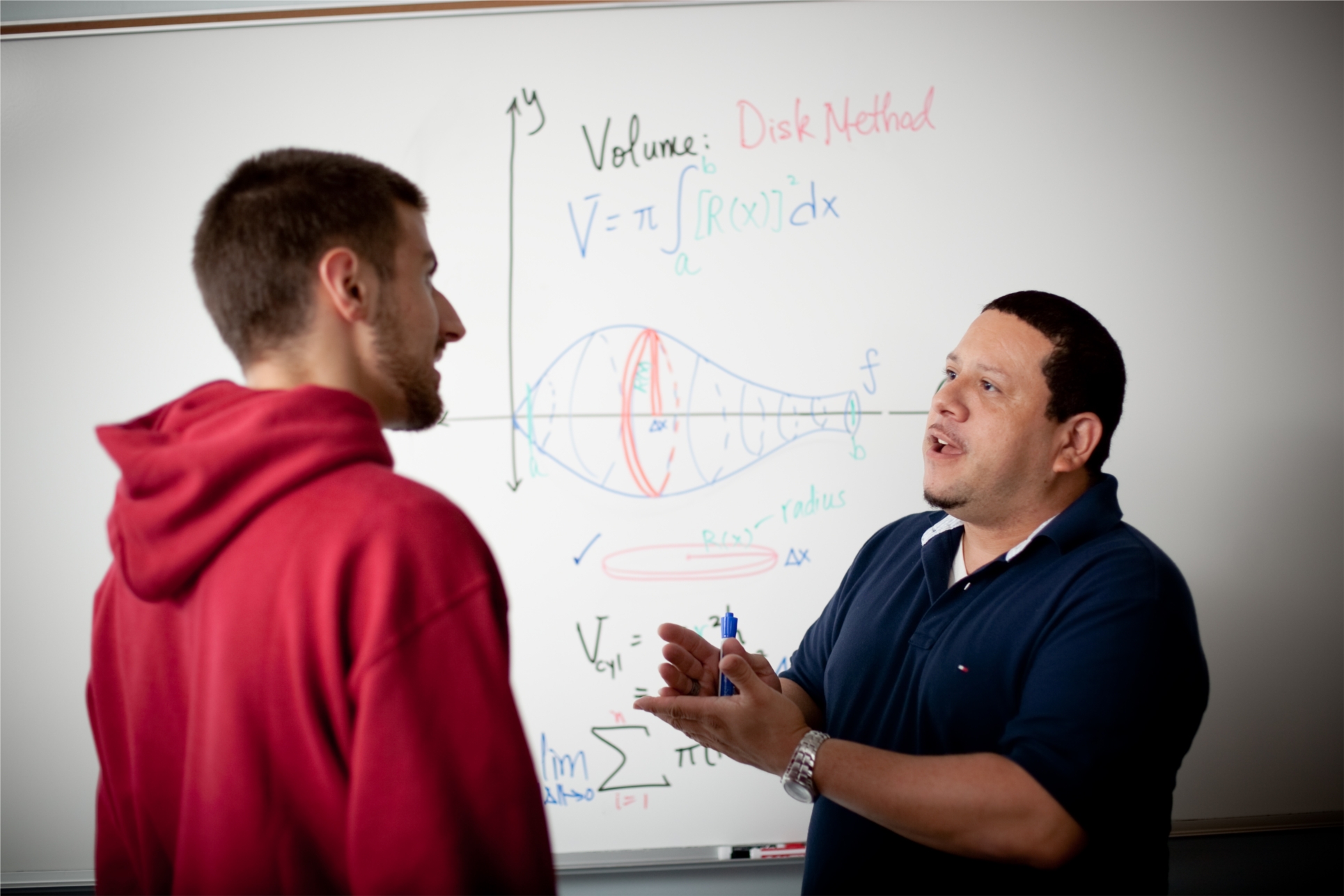 Alex Rolón, associate professor of mathematics, explains an equation.