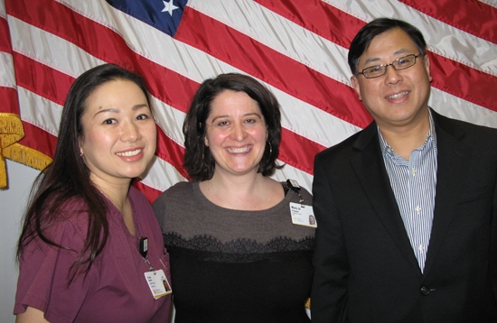 HSL offers free classes for employees, who wish to become US Citizens, to prepare them for their US Citizenship exam. Two HSL employees stand with their instructor following their US Citizen swearing-in ceremony.