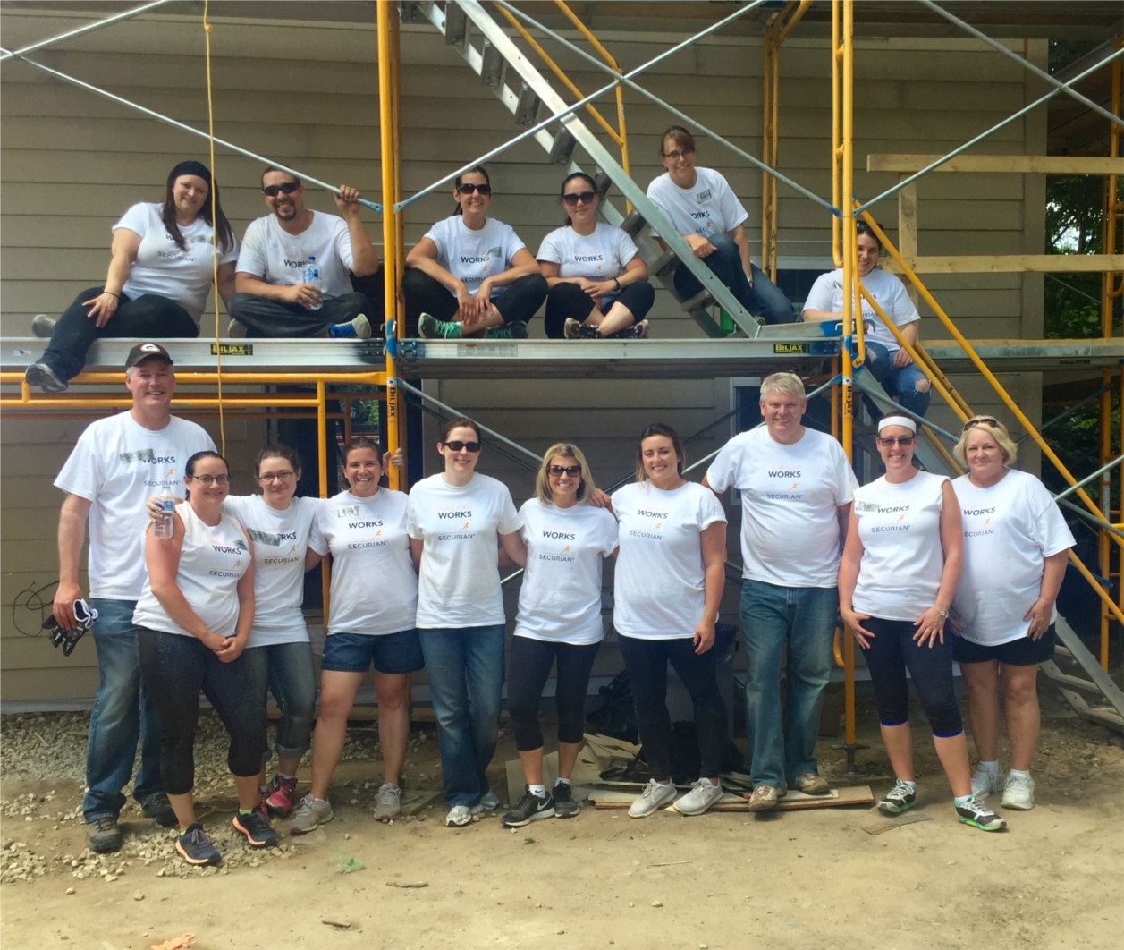 Associates take a break to pose for a picture while assisting in a Habitat for Humanity home build.  In 2016, associates volunteered 154 hours for this worthy cause.