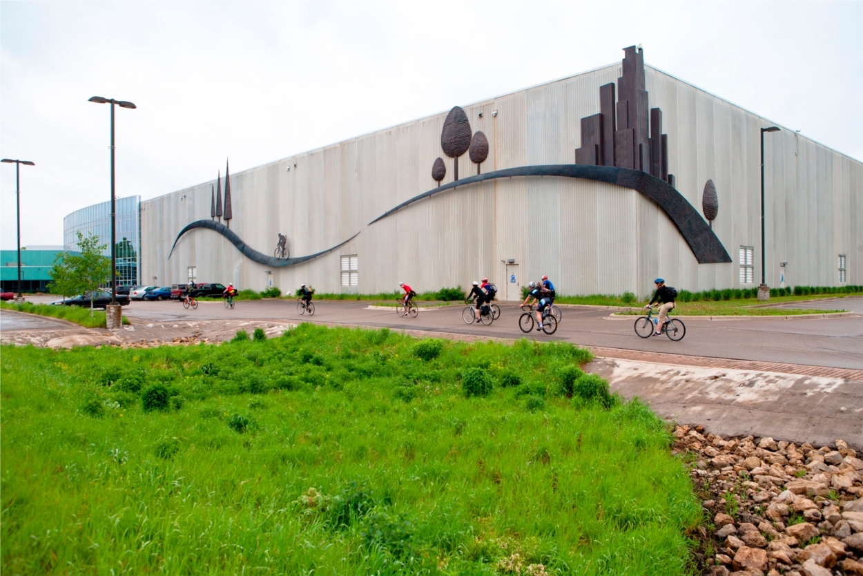 Bike commuters roll past the 255-foot-long bicycle sculpture adorning QBP headquarters in Bloomington, MN.