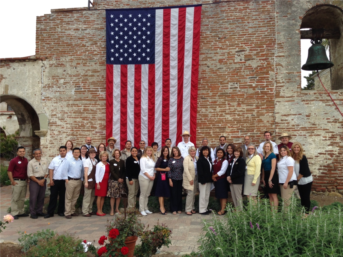 Historic Mission San Juan Capistrano staff pose at Bell Wall prior to 10th Annual Battle of the Mariachis festival