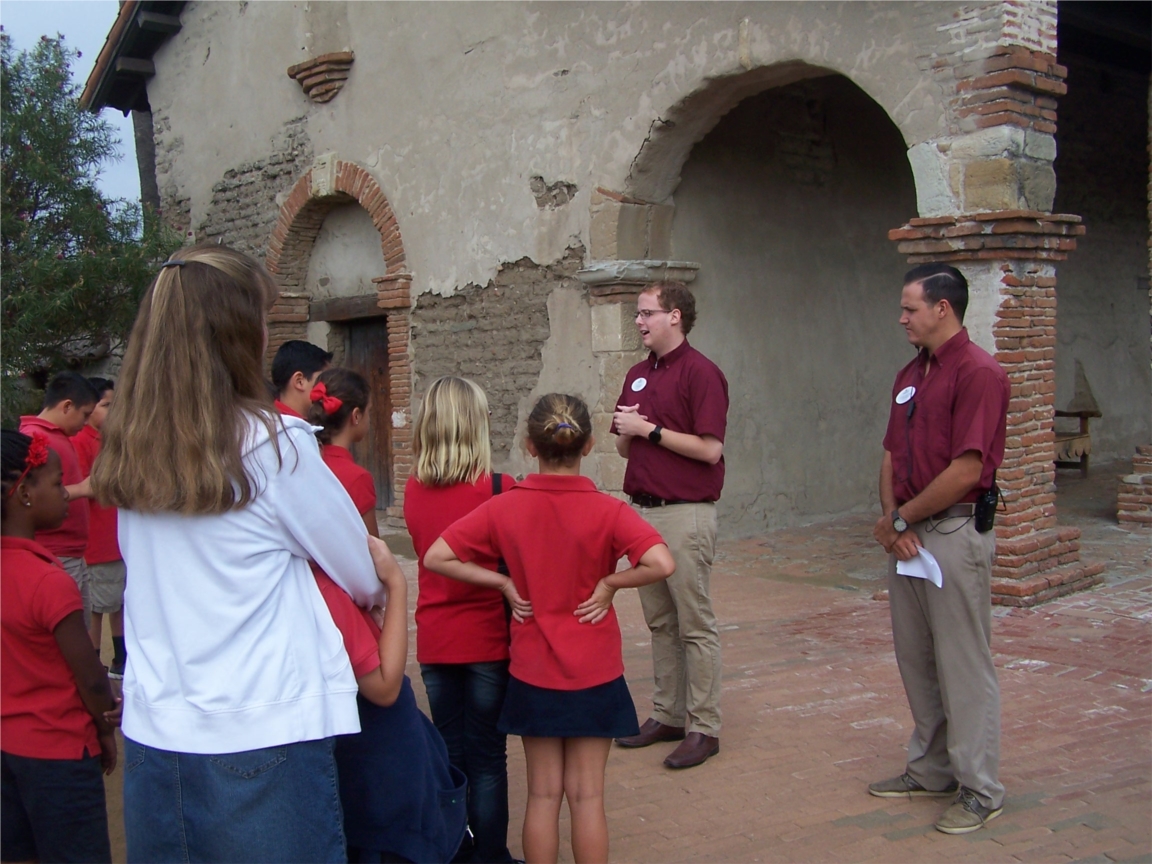 Historic Mission Guest Services staff, Lucas Scofield and Thomas Cantrell, greet 4th grade students touring the mission and attending educational class.