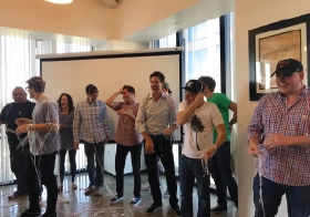 MFour Sales Team wiping off strands of silly string after an office silly string battle.