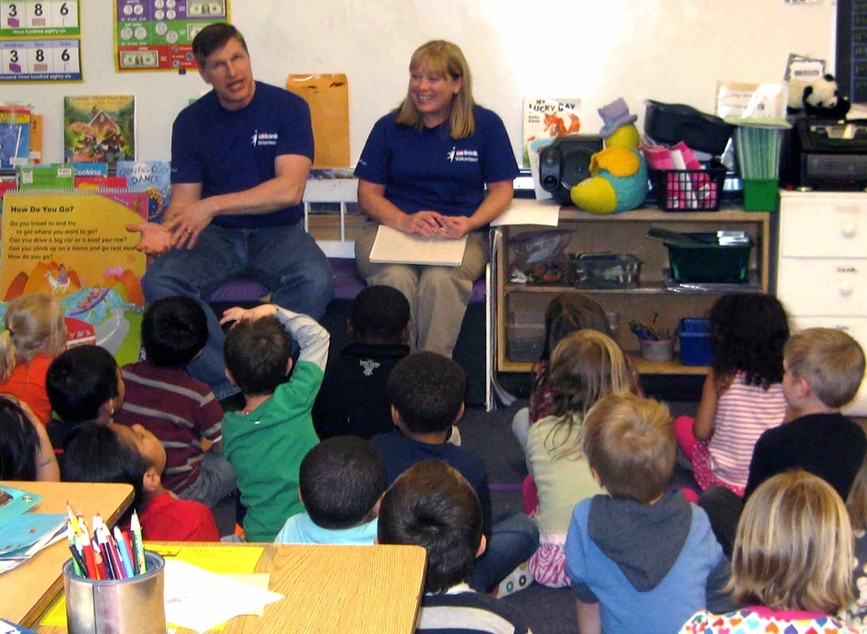 Two U.S. Bank employees talk with kindergartners about saving money for Teach Children To Save Day. 