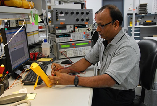 Employee K Rajkumar is calibrating a Fluke 87 V Digital multimeter.