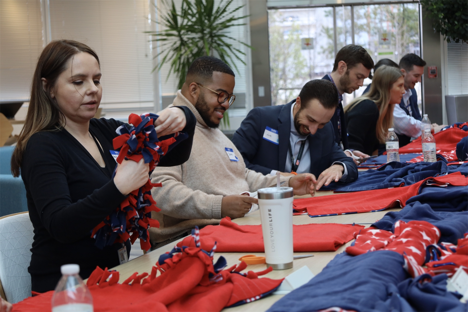 Employees participating in making blankets for military veterans in hospice care