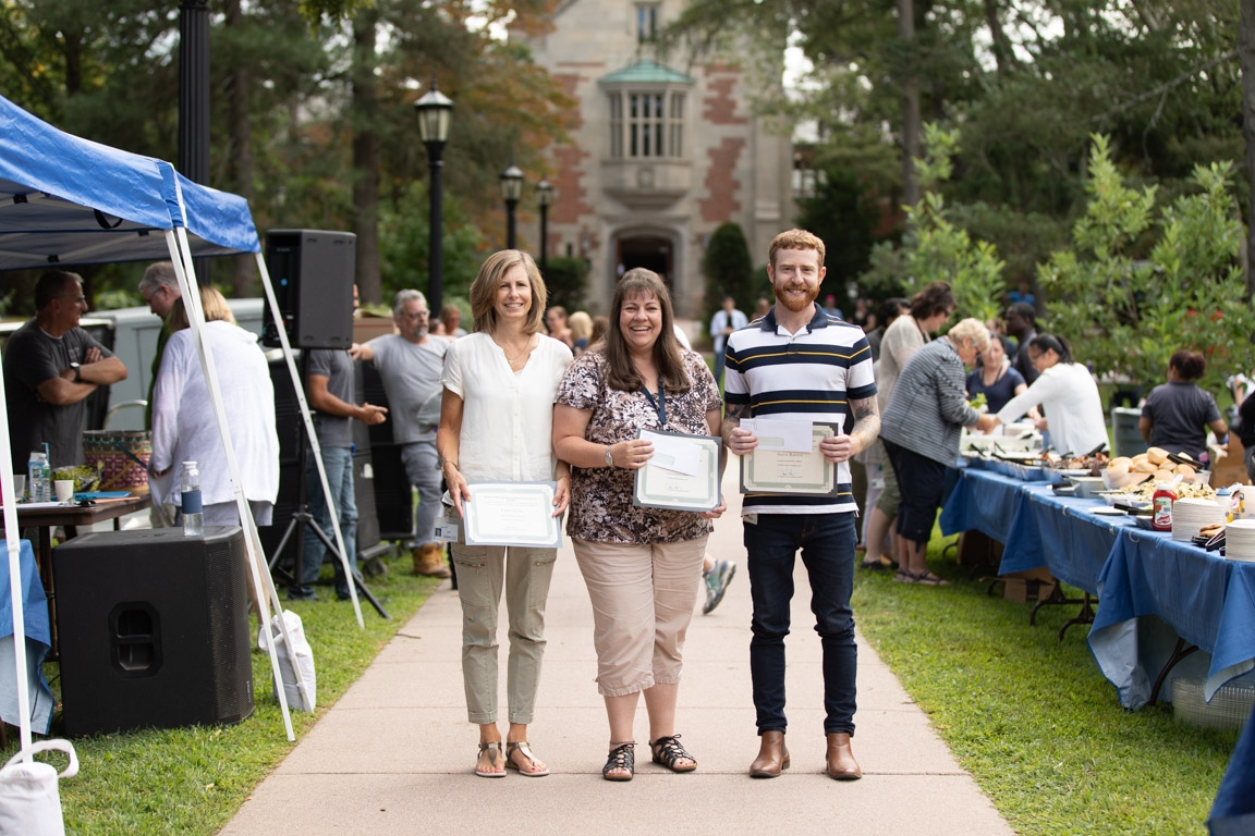 The three winners of this year's Janet & William James award pose with their certificate on the sidewalk in front of Howe.