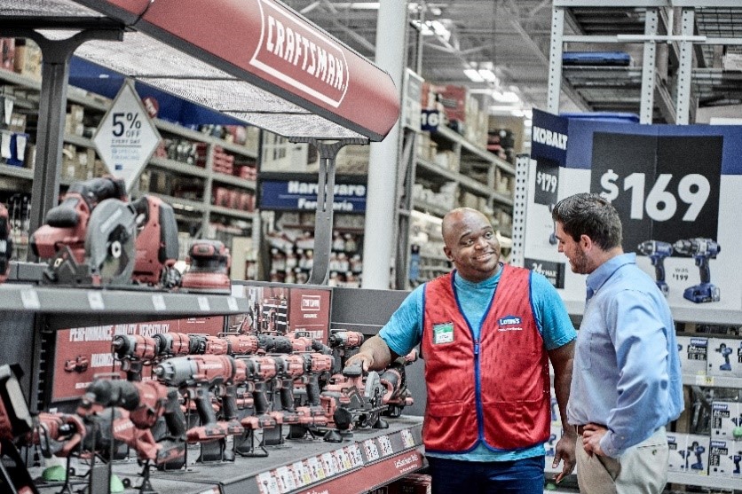 A Lowe's associate assisting a customer in a Lowe's store.