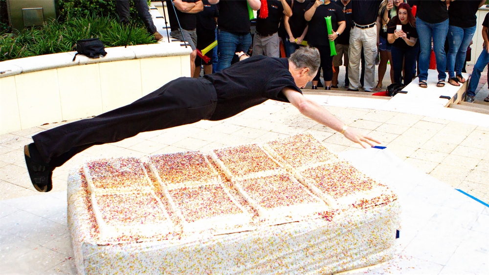 KnowBe4's CEO, Stu, jumps into a giant cake for KnowBe4's 8th anniversary