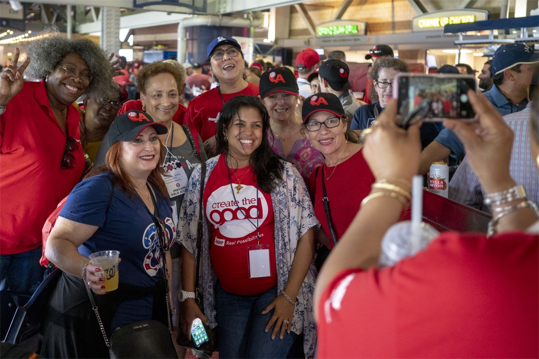 AARP CEO Jo Ann Jenkins poses with AARP staff during a Washington Nationals baseball game.