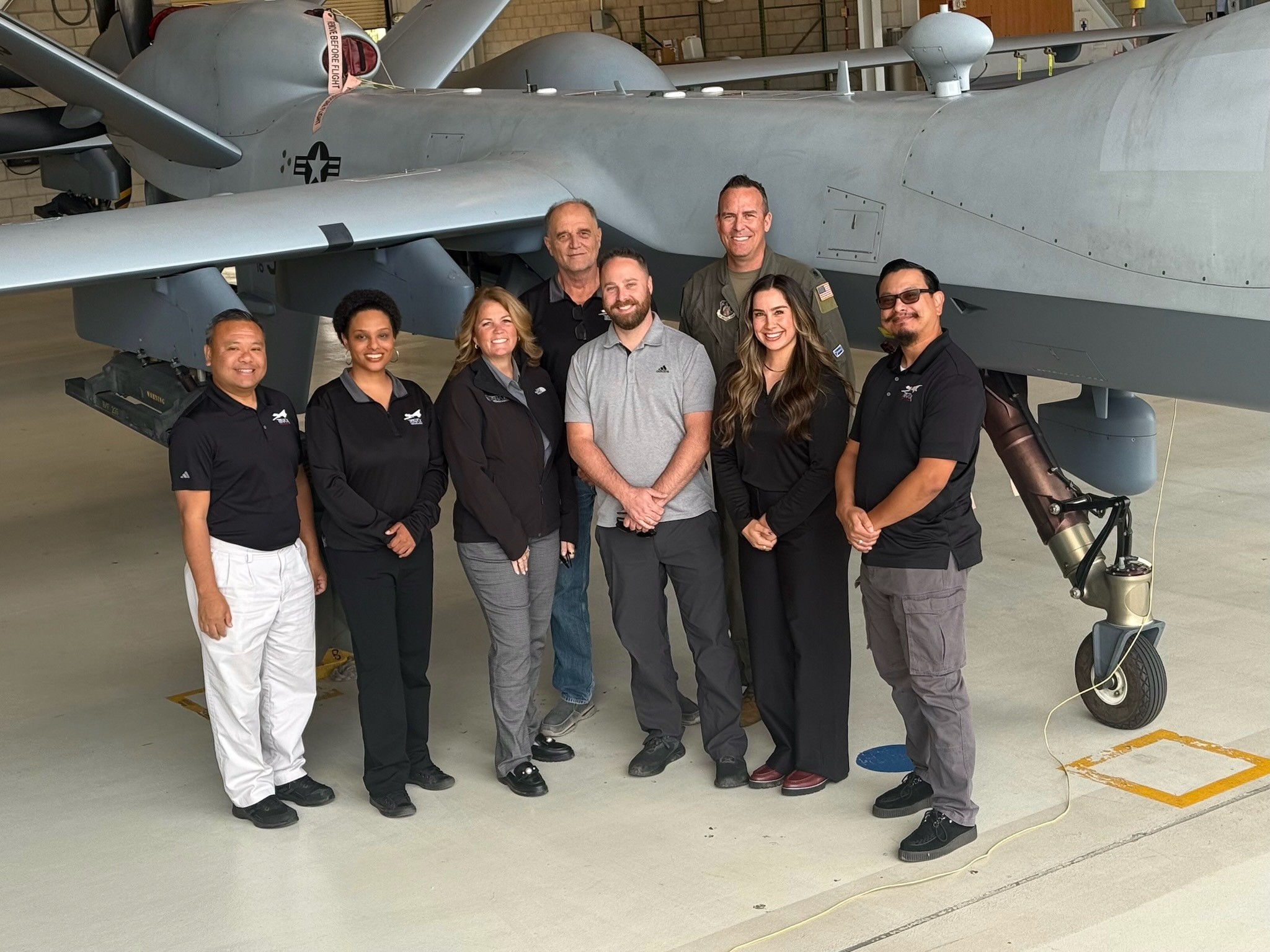 TENAX employees standing in front of a drone they manage.