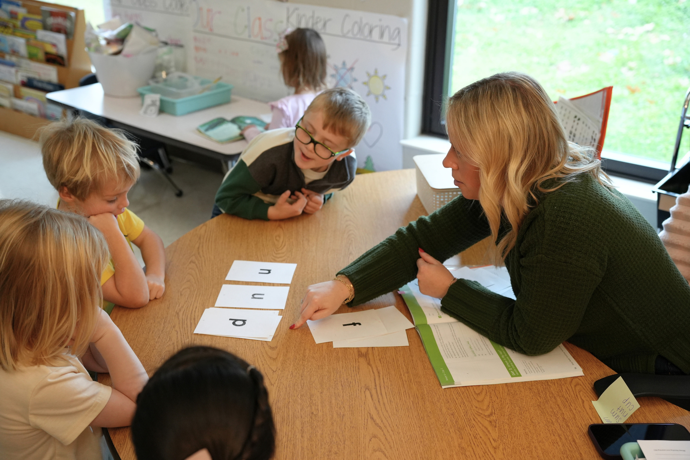 Kindergarten students participate in a small-group reading lesson.