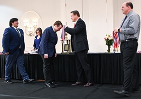 PAGE Executive Director awards medals at the Georgia Academic Decathlon.