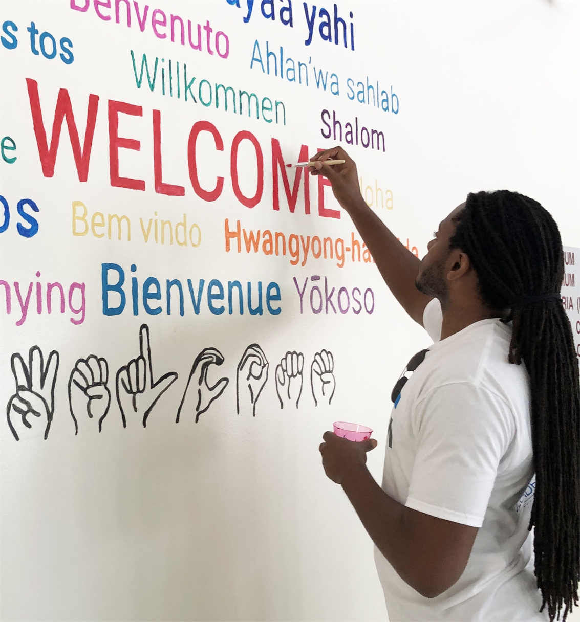 RSM volunteer paints signage at a local school