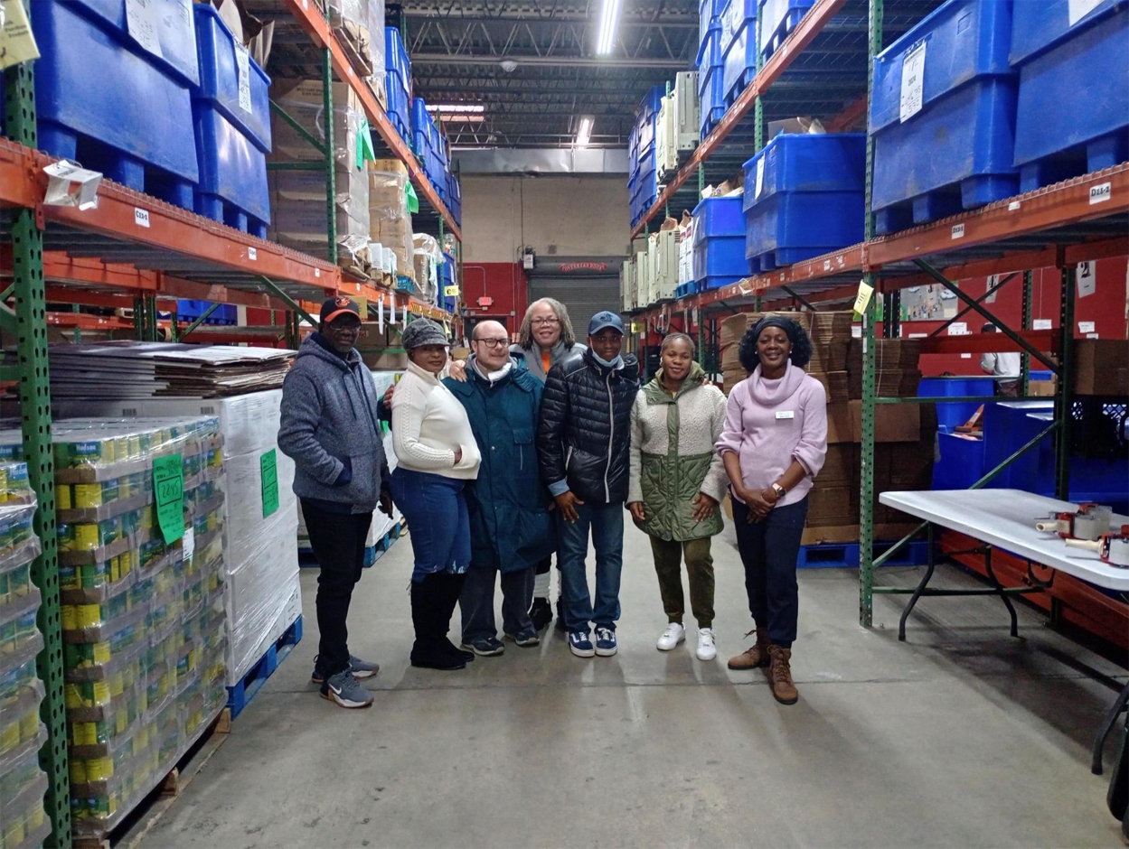 Compass participants and staff inside of a food bank warehouse