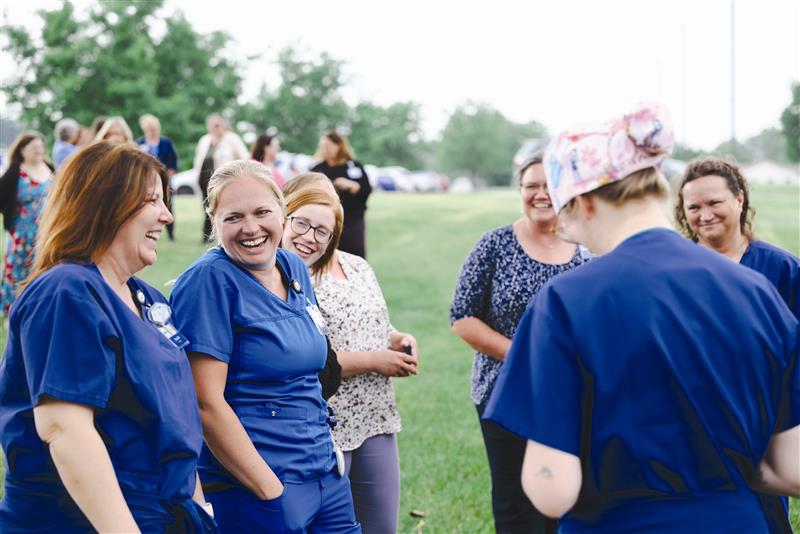 2023.Ribbon Cutting.Staff Talking.CMYK.jpg