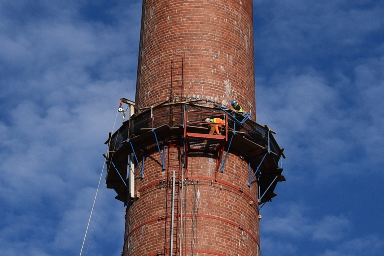 Crews inspect a 250-foot-tall chimney-like structure dates from the 1940s that still still provides ventilation to operations at ORNL.