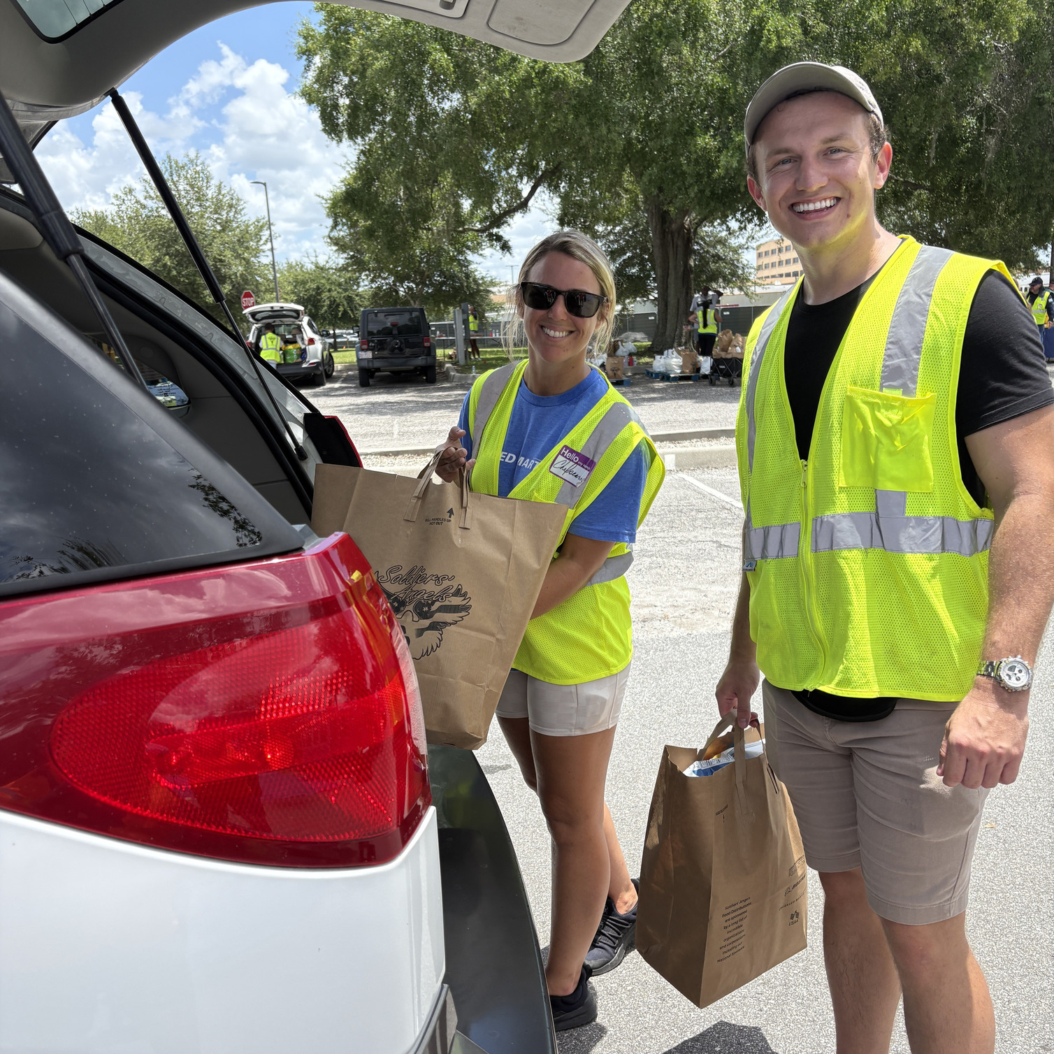 Soldiers' Angels volunteers loading groceries into the car of a Veteran in need