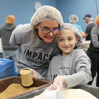 LAVIDGE IMPACT includes family in community service projects, like this one to pack food for the hungry..