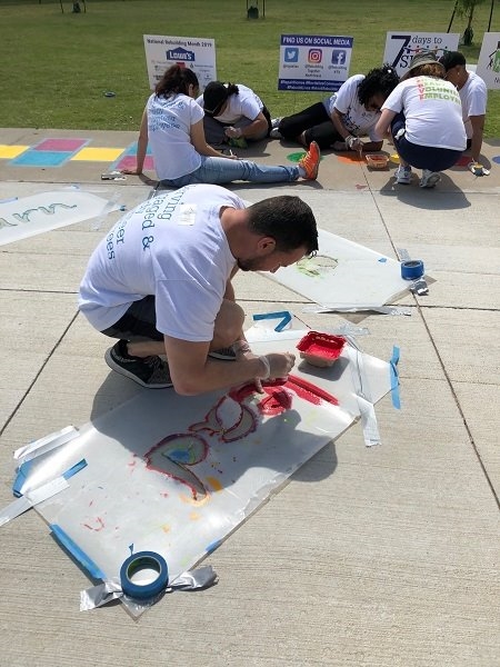 Fannie Mae employee Tony Gallo creates sidewalk games at a Collin County elementary school during the company's annual 7 Days to SERVE