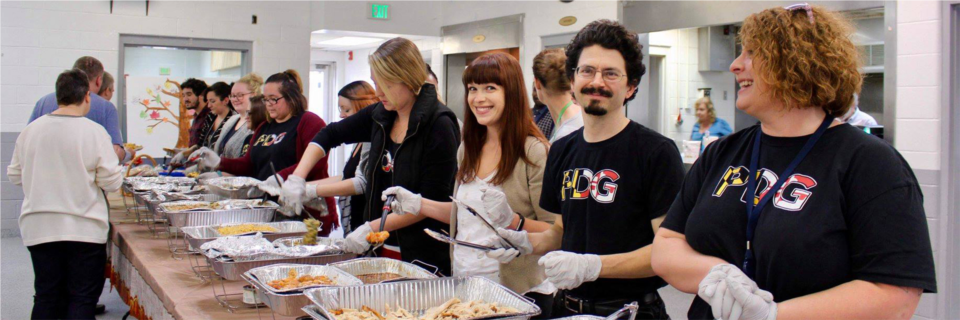 PDG staff serving our annual home-cooked Thanksgiving feast to consumers with mental disabilities. 