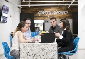 Clearview Group employees holding a meeting in the expansive "Grit & Grind" lounge used for team happy hours, business meetings and events. 