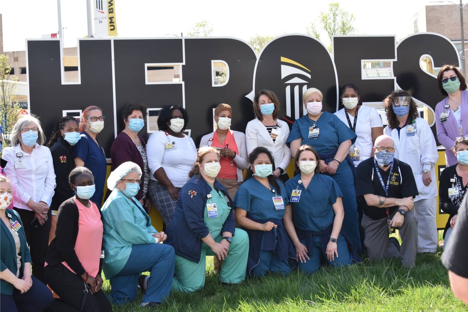 UM BWMC employees pose in front of "Heroes Work Here" sign, in support of their brave work during the COVID-19 response.