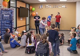 Children being entertained by an acting troupe at Young Buick GMC's Spring into Literacy event, which benefits the Davis Education Foundation