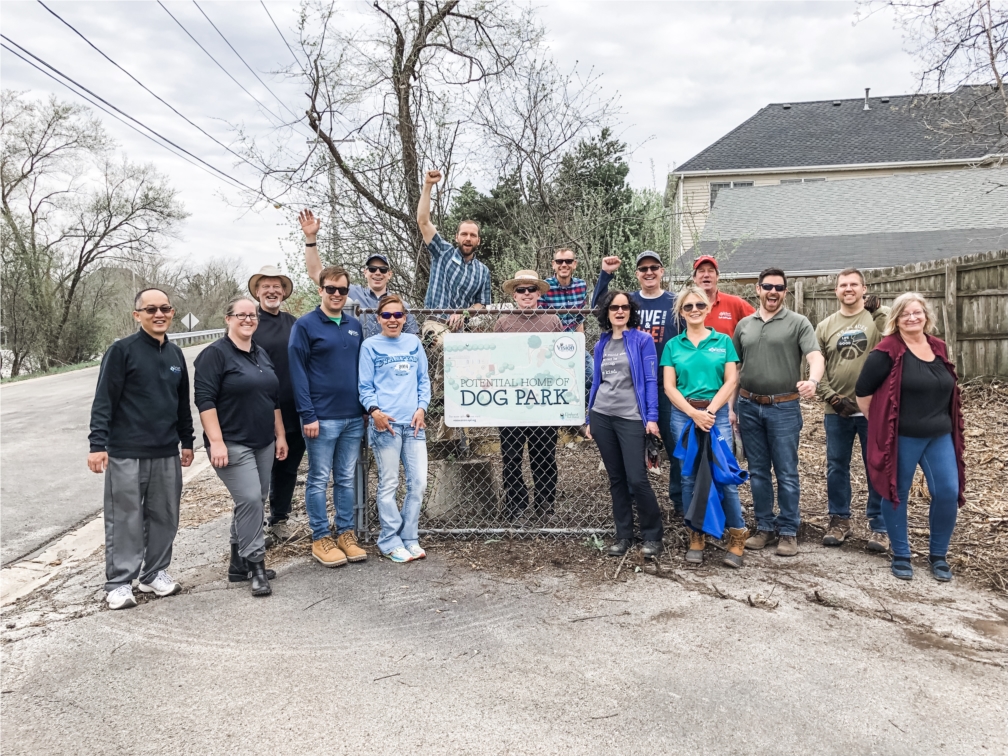 Employees cleaning up a potential dog park within Elmhurst on Earth Day. 