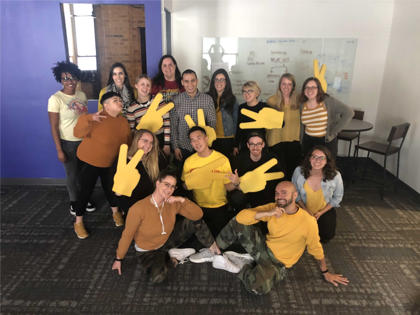 Chicago Design, Marketing, and Talent & Culture teams pose for a team member's last day before transferring to our San Francisco office (his favorite color is yellow!)