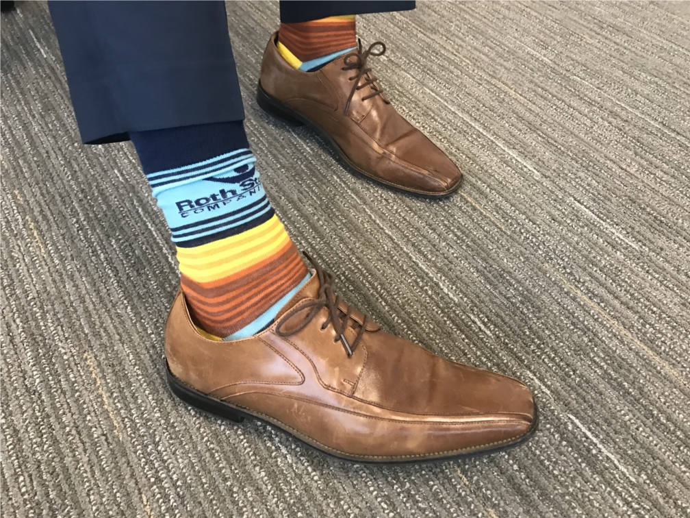 Coworker shows off Roth Staffing socks. 