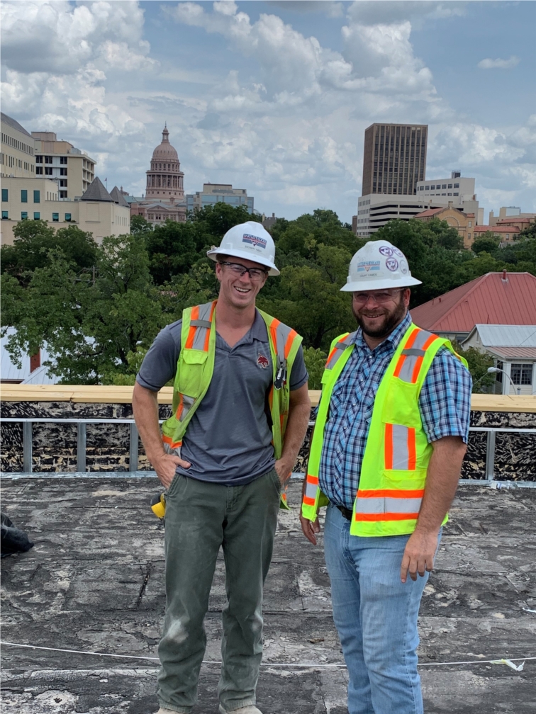 A couple of employees at a jobsite with the view of the Capital. 
