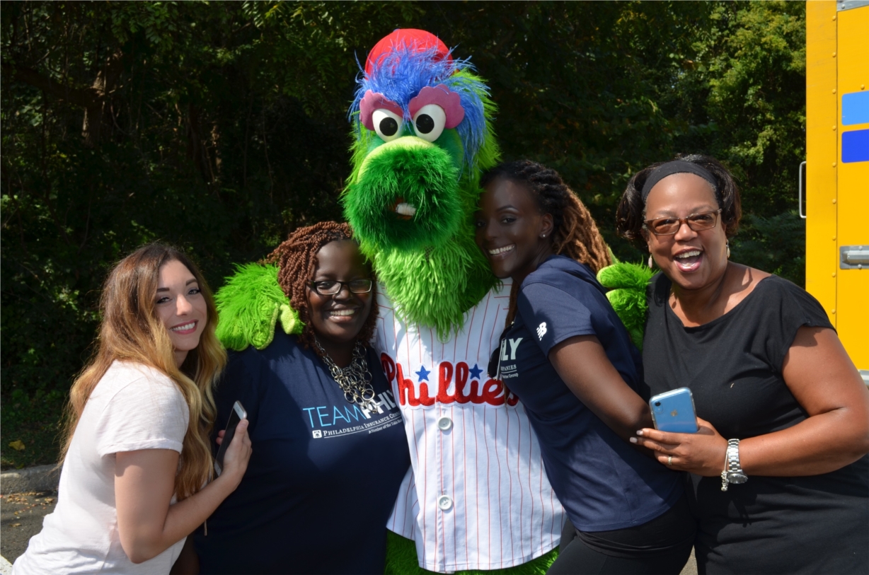 Employees enjoying a day of fun filled outdoor wellness activities with the Phillie Phanatic during PHLY's annual  health and wellness picnic.