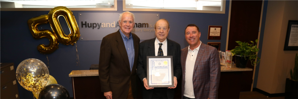 Attorneys Michael Hupy and Jason Abraham with Milwaukee Mayor Tom Barrett and city proclamation declaring April 15, 2019 as "Hupy and Abraham Day."