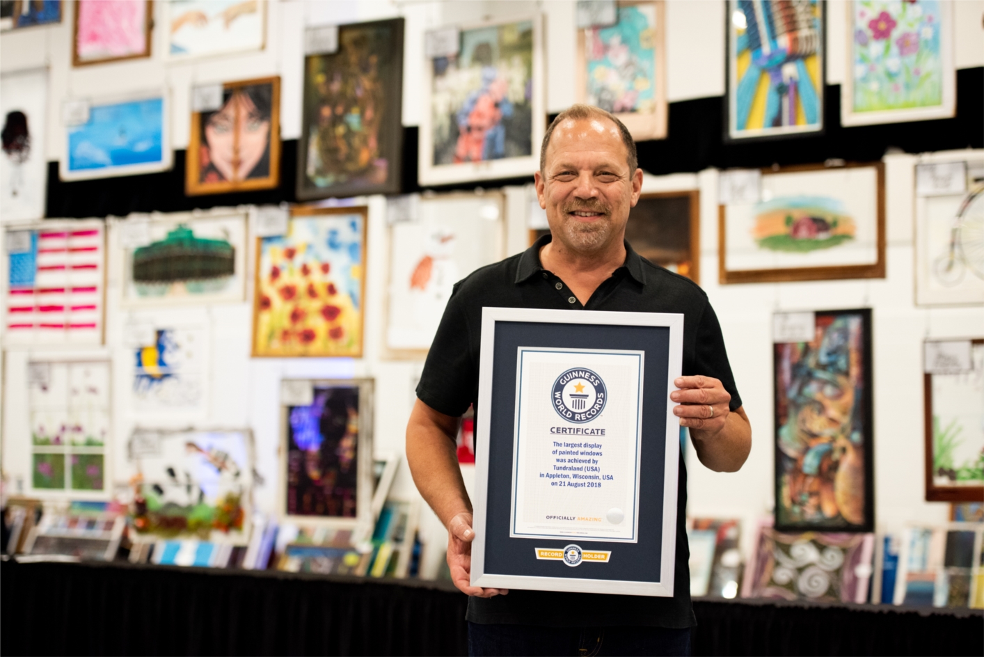 President of Tundraland, Brian Gottlieb takes a photo with the company's Guinness World Record Title for the Largest Display of Painted Windows. 